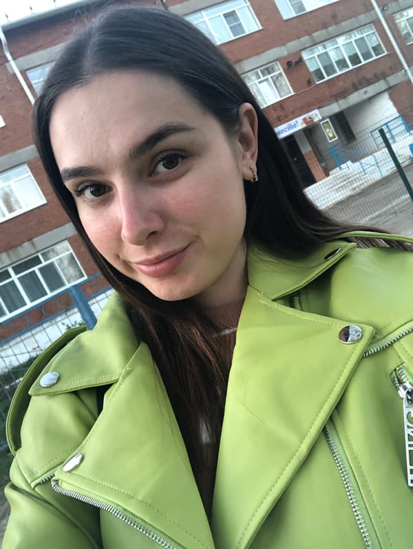 Woman poses near school bus in Noviy, Russia