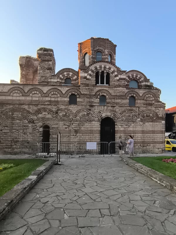 Evening in Nesebar: ruins, rocky shore, and harbor lights