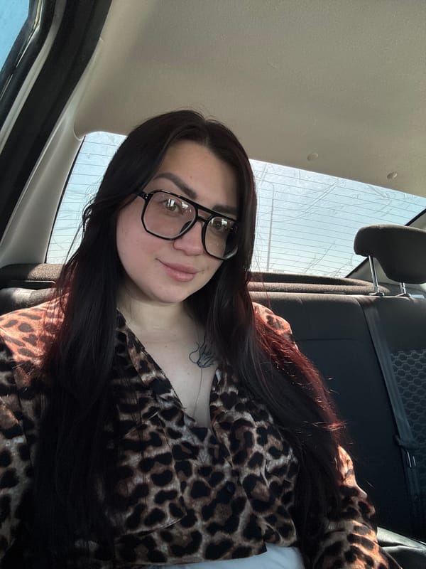 Woman in leopard-print shirt photographed inside vehicle
