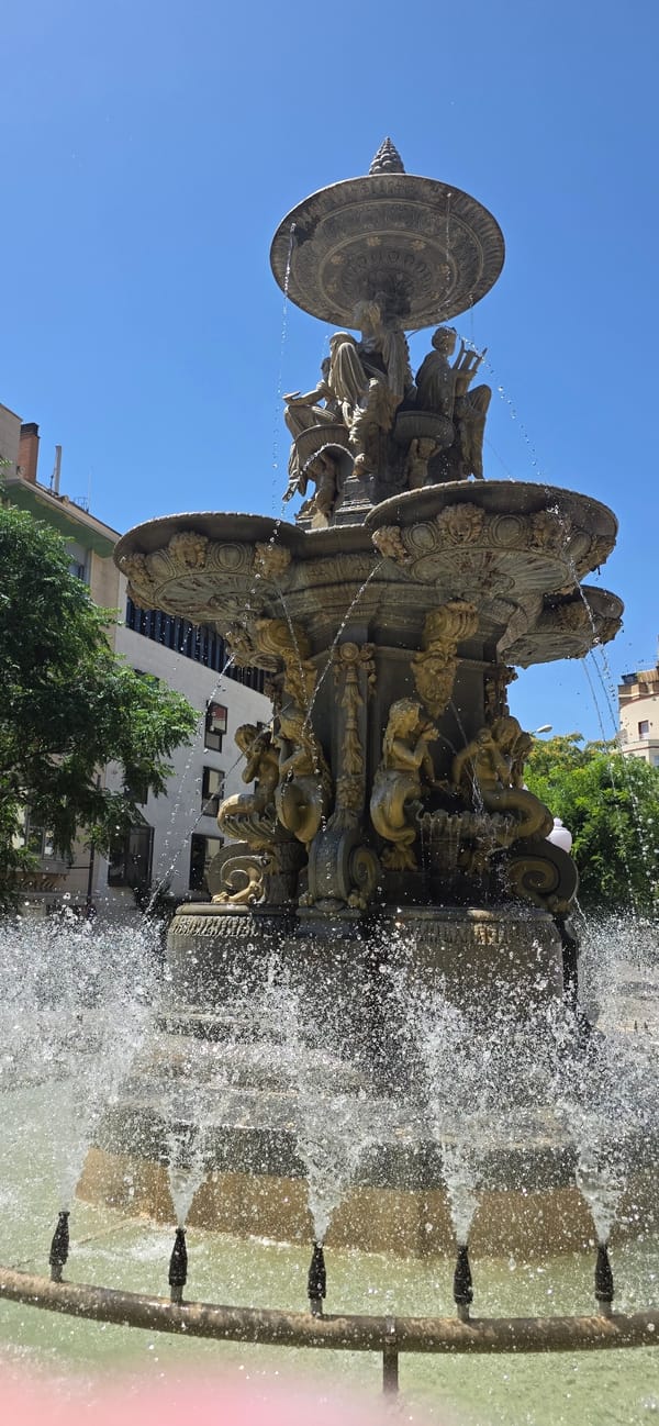 Ornate fountain and blooming gardens in Huesca's sunny plaza