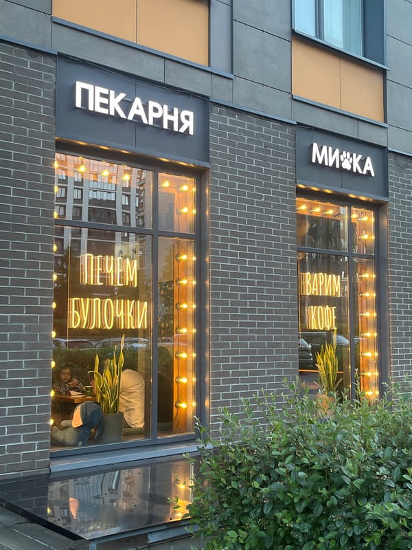 Person photographs Russian bakery storefront from parking lot