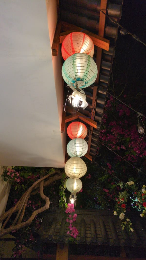 Colorful paper lanterns displayed along wall in Vietnamese city
