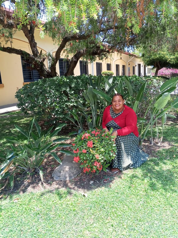 Woman poses in flowering garden in La Victoria