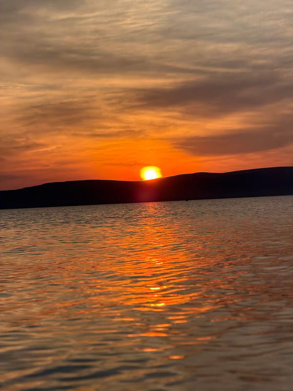 Sunset evening at a Siberian lake, mountains on the horizon