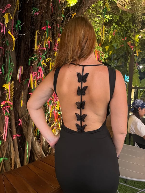 Black butterfly dress at a ribbon-decorated tree in Thailand