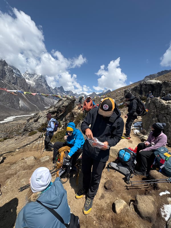 Hikers rest on steep mountain trail near Khumjung, Nepal