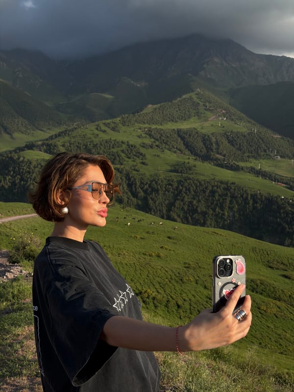 Tourists document verdant mountain scenery in Kashka Suu, Kyrgyzstan