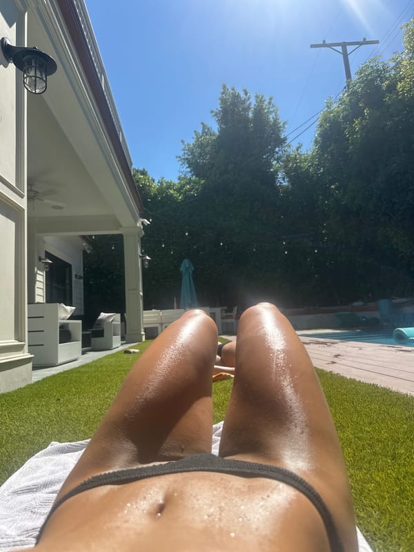 Person sunbathing on artificial turf in Los Angeles backyard