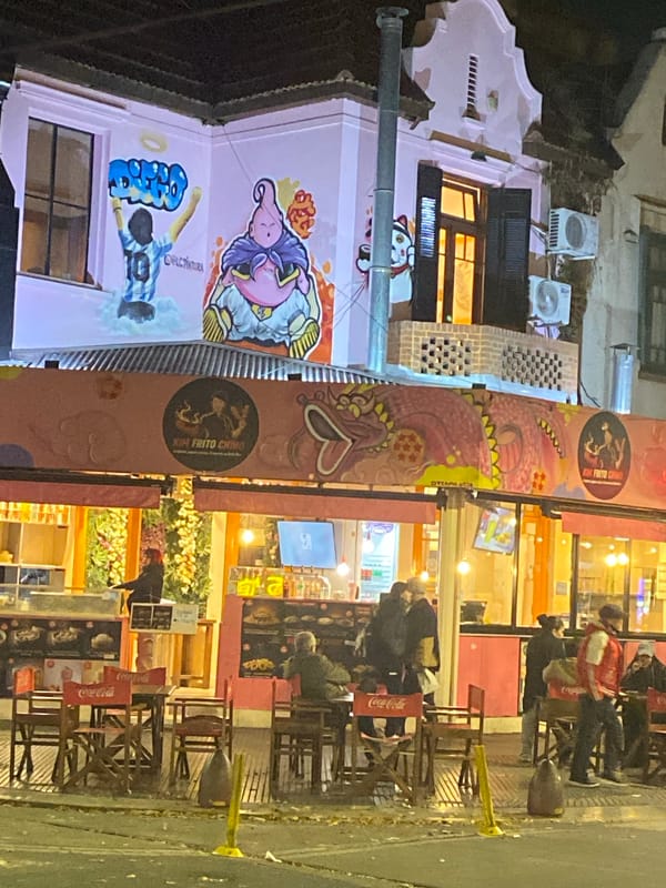 Street art murals documented on pink building in Buenos Aires