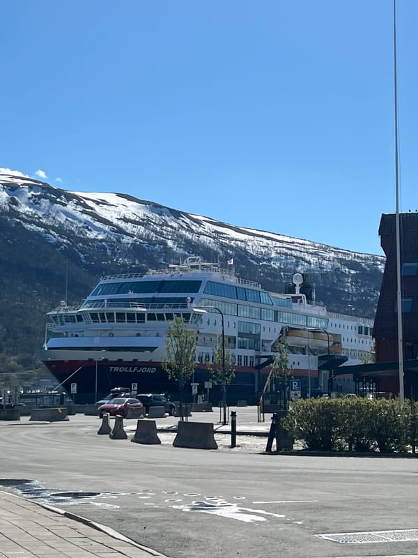 Cruise ship Trollfjord docks in Tromsø amid snowy mountains