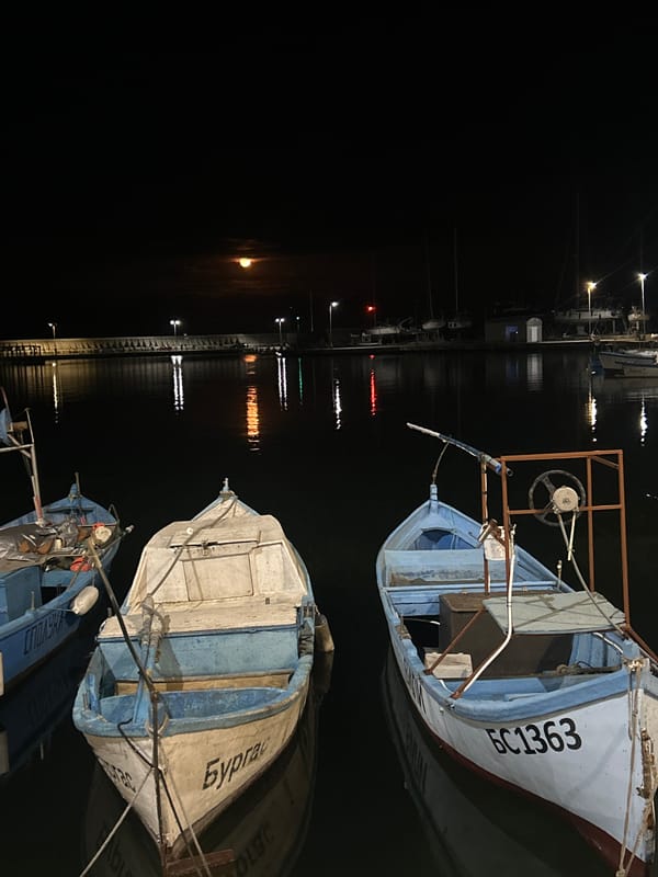 Fishing boats docked at nighttime Burgas harbor pier