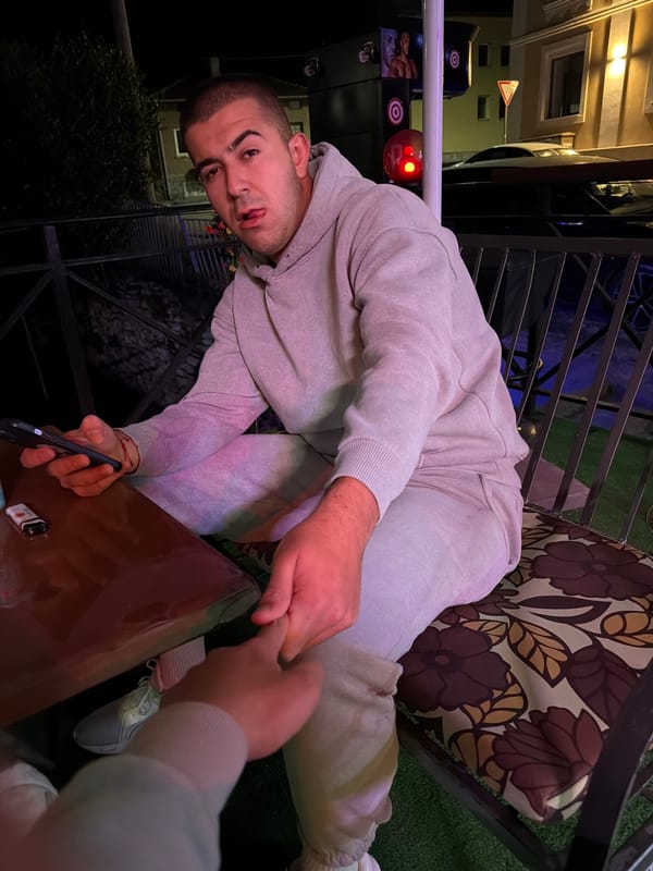 Young man photographed at outdoor evening gathering in Bania