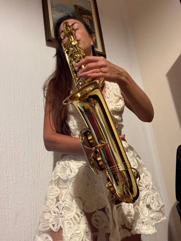 Woman performs saxophone indoors in Montenegro coastal town