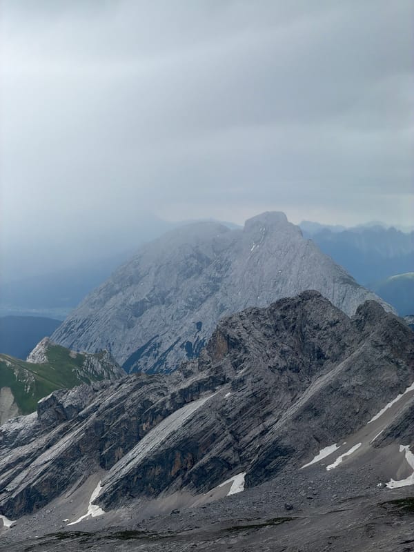 Snow-patched rocky ridges under cloudy skies in the Bavarian Alps
