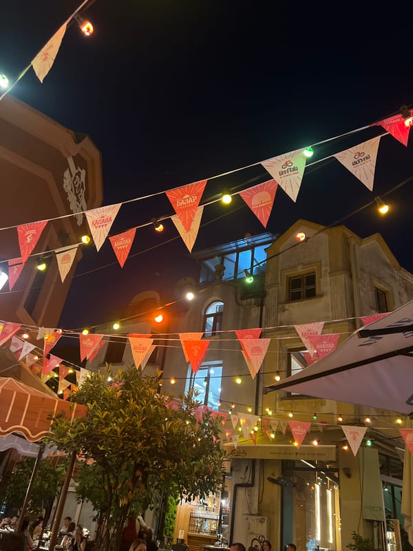 Outdoor cafe evening with string lights and wine on the table