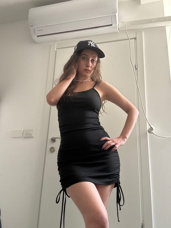 Woman photographed indoors in black dress, Ramat Gan