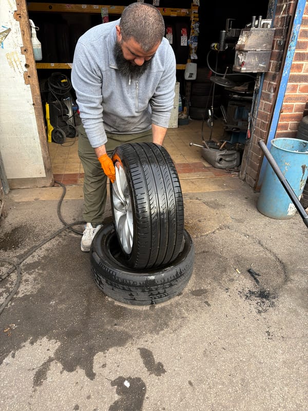 Man handles tires in garage workspace in Wakefield