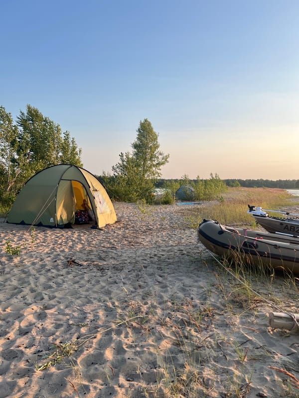 Tent and inflatable boats on a sandy beach near Borovoe