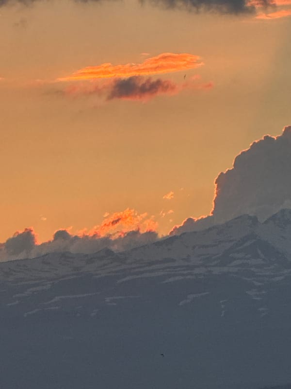 Stormy sunset sky over Abovyan, Armenia, with birds in flight.