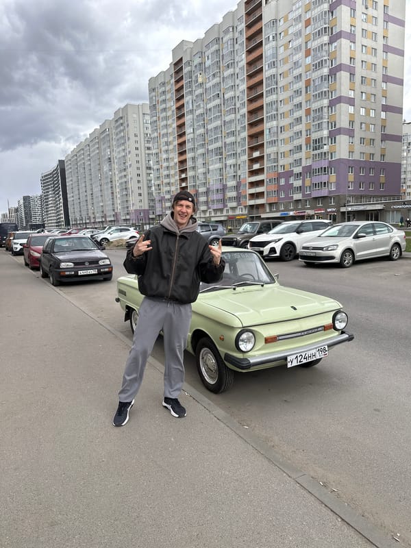 Man poses with vintage green car in Murino