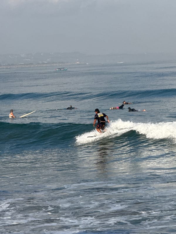 Busy surf session on a hazy morning at Kuta Beach