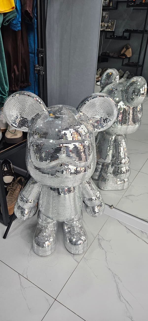 Mirror-tiled cartoon sculptures displayed in indoor venue