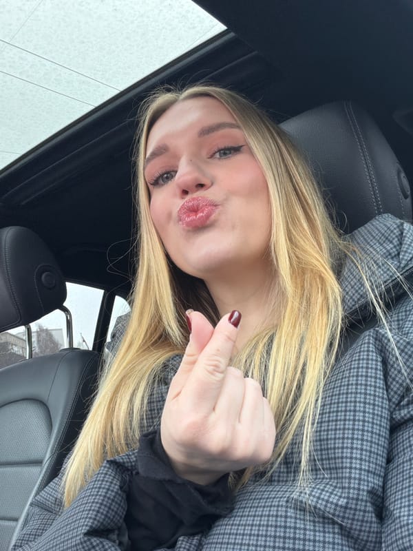 Woman poses for photo in car seat in Riga