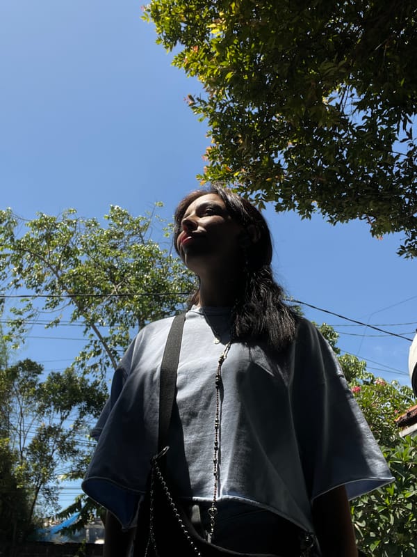 Woman photographed with scooter amid tropical scenery in Kuta Selatan