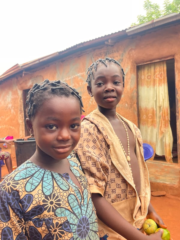 Children in traditional dress photographed in Nigerian courtyard