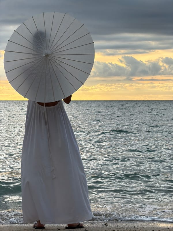 Beached boats and a white parasol on a Koh Samui shore