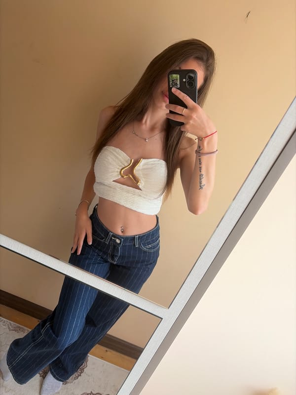 Young woman takes indoor mirror selfie, location unknown