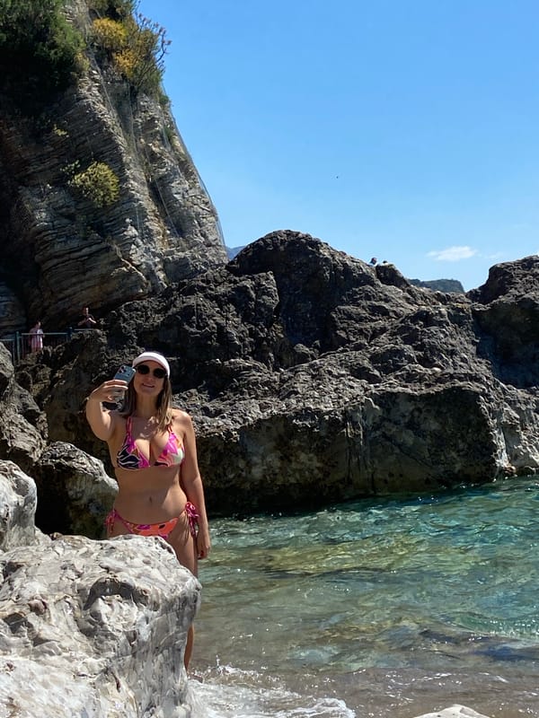 Woman takes selfie on rocky beach in Budva, Montenegro