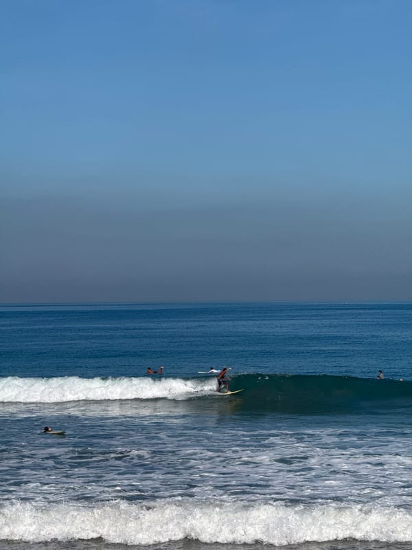 Kuta Beach surf session with street activity nearby