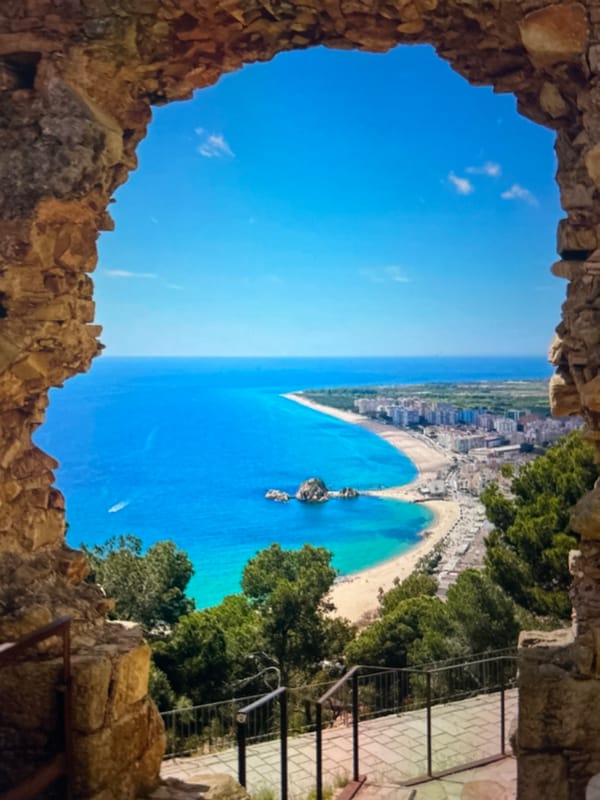 Tourists document coastal cliffs and historic streets during afternoon sightseeing