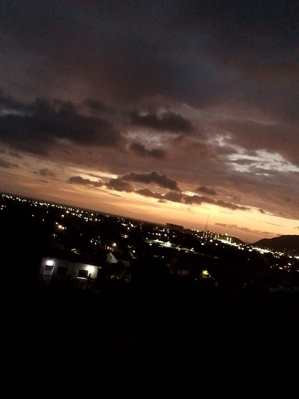 Twilight clouds display orange, purple hues over Altagracia cityscape