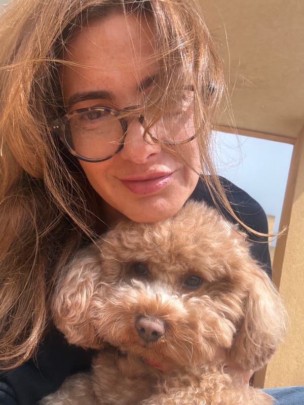 Woman cuddles with small dog in Portugal selfie