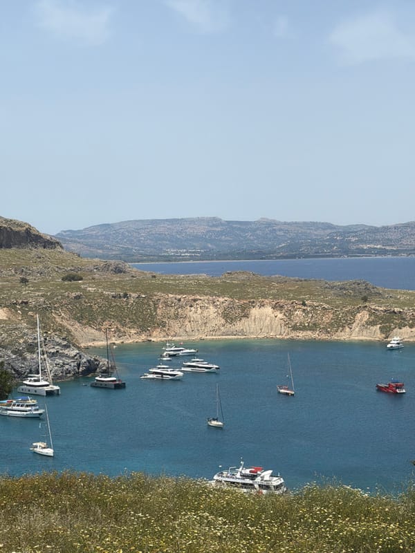 Boats anchored in Lindos bay under clear skies