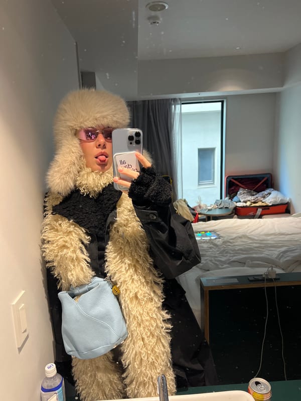 Person takes mirror selfie in messy Shibuya room