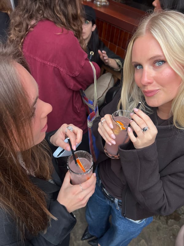 London sidewalk gathering features pink cocktails with orange garnishes