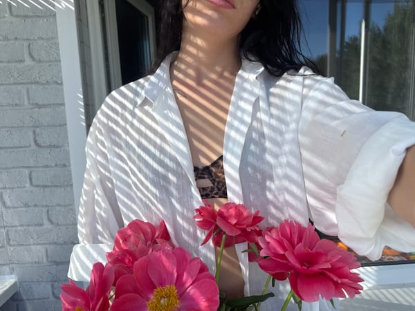 Woman photographs herself with flowers on Chaikovsky balcony