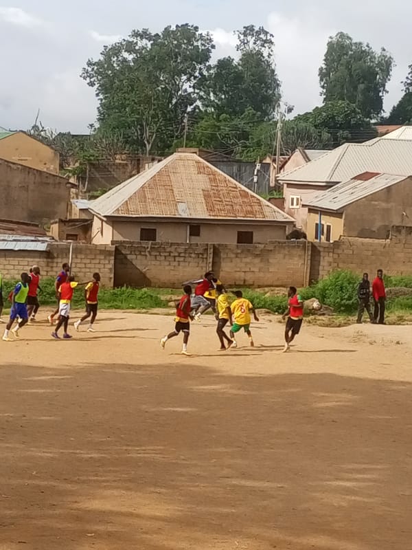Pickup football on a rocky dirt field in Jos, Nigeria