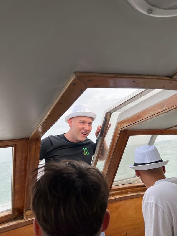 Tourists photograph from boat cabin during Venice excursion
