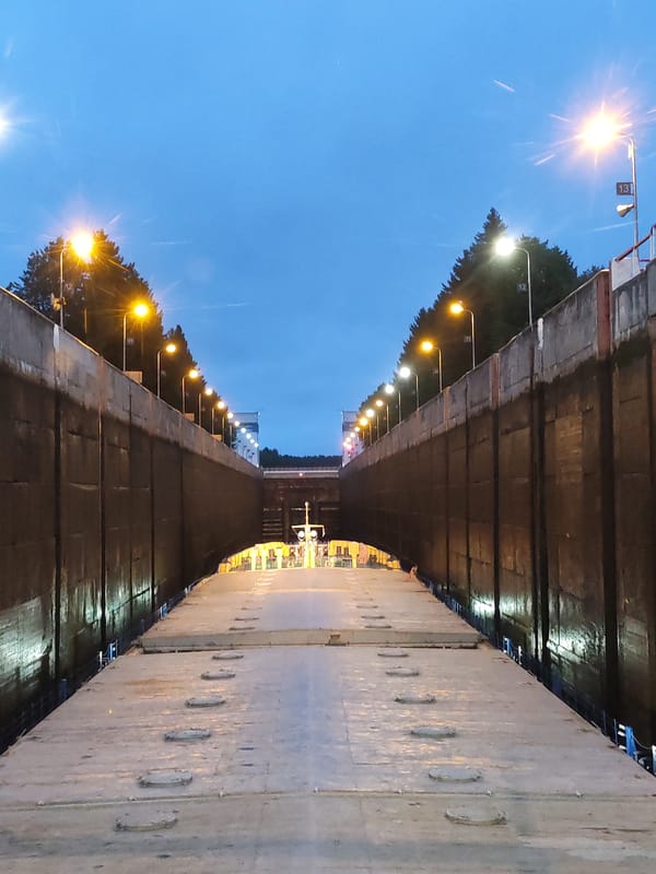 Barge passing through an open canal lock at dusk, Markovo