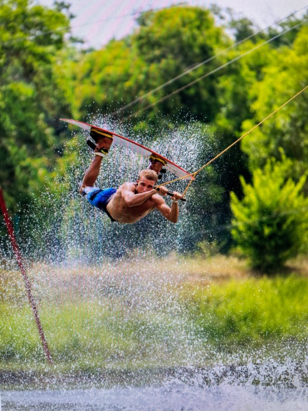 Wakeboarder performs aerial tricks on water in Bacong, Philippines