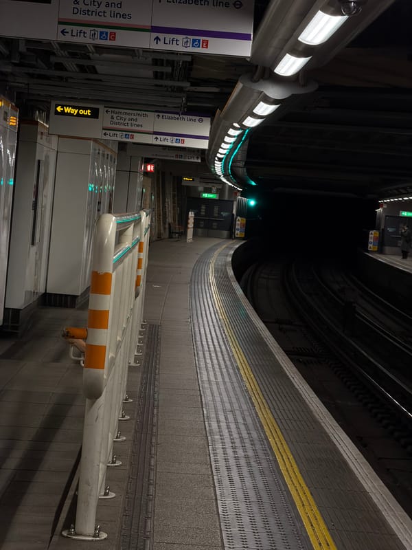 London Underground platform observed with curved fluorescent lighting