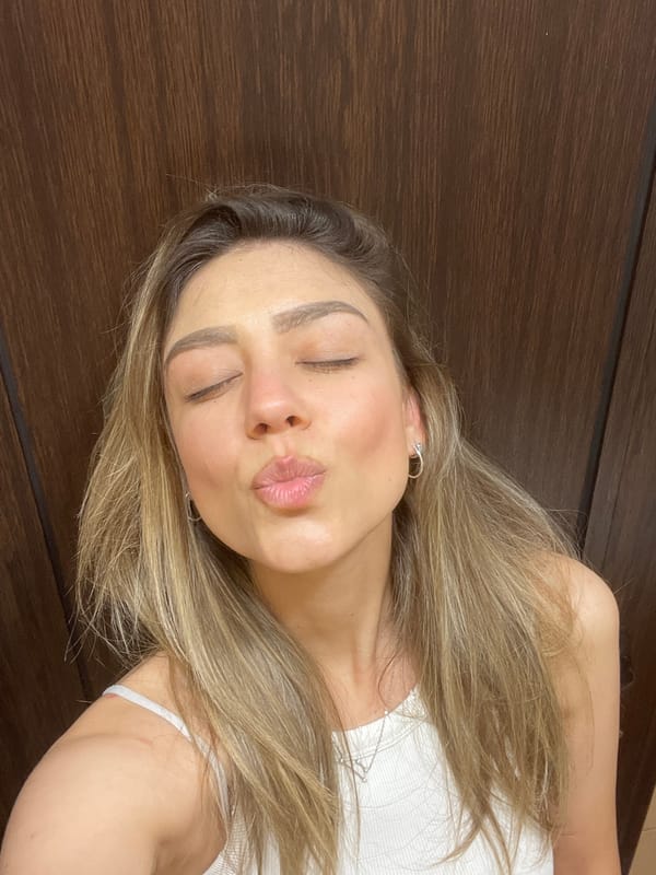Woman photographed making kissing face, exhaling vapor in evening