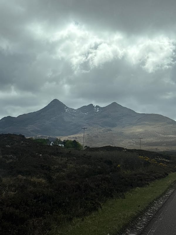 Cloudy skies frame snow-dusted mountains on Isle of Skye