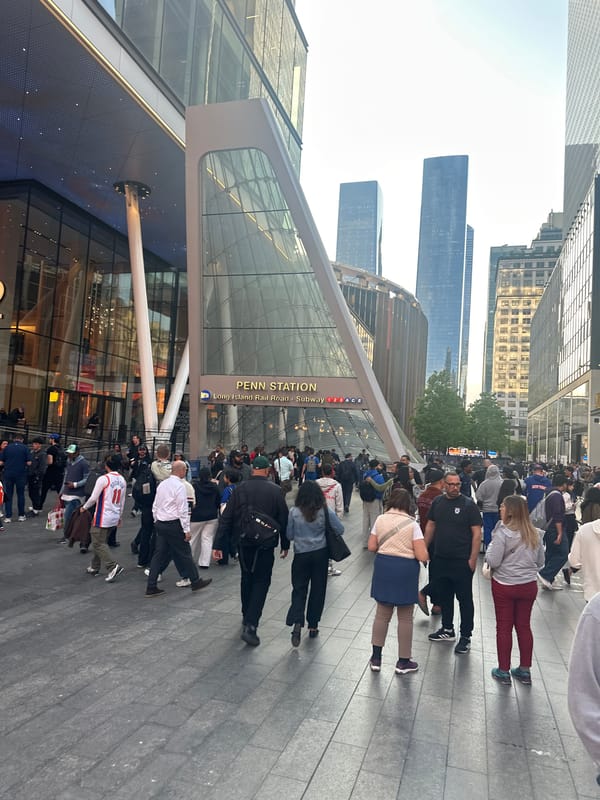 Crowd gathers at modern NYC building with digital displays