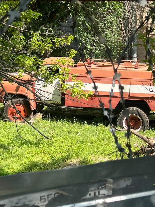 Morning stroll through a city park with an abandoned fire truck nearby