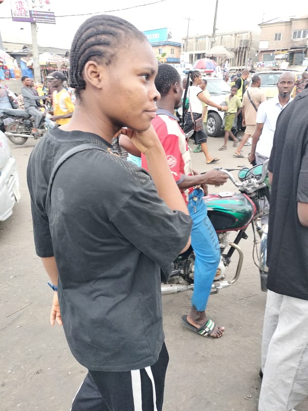 Schoolgirls walk busy Lagos street during morning rush